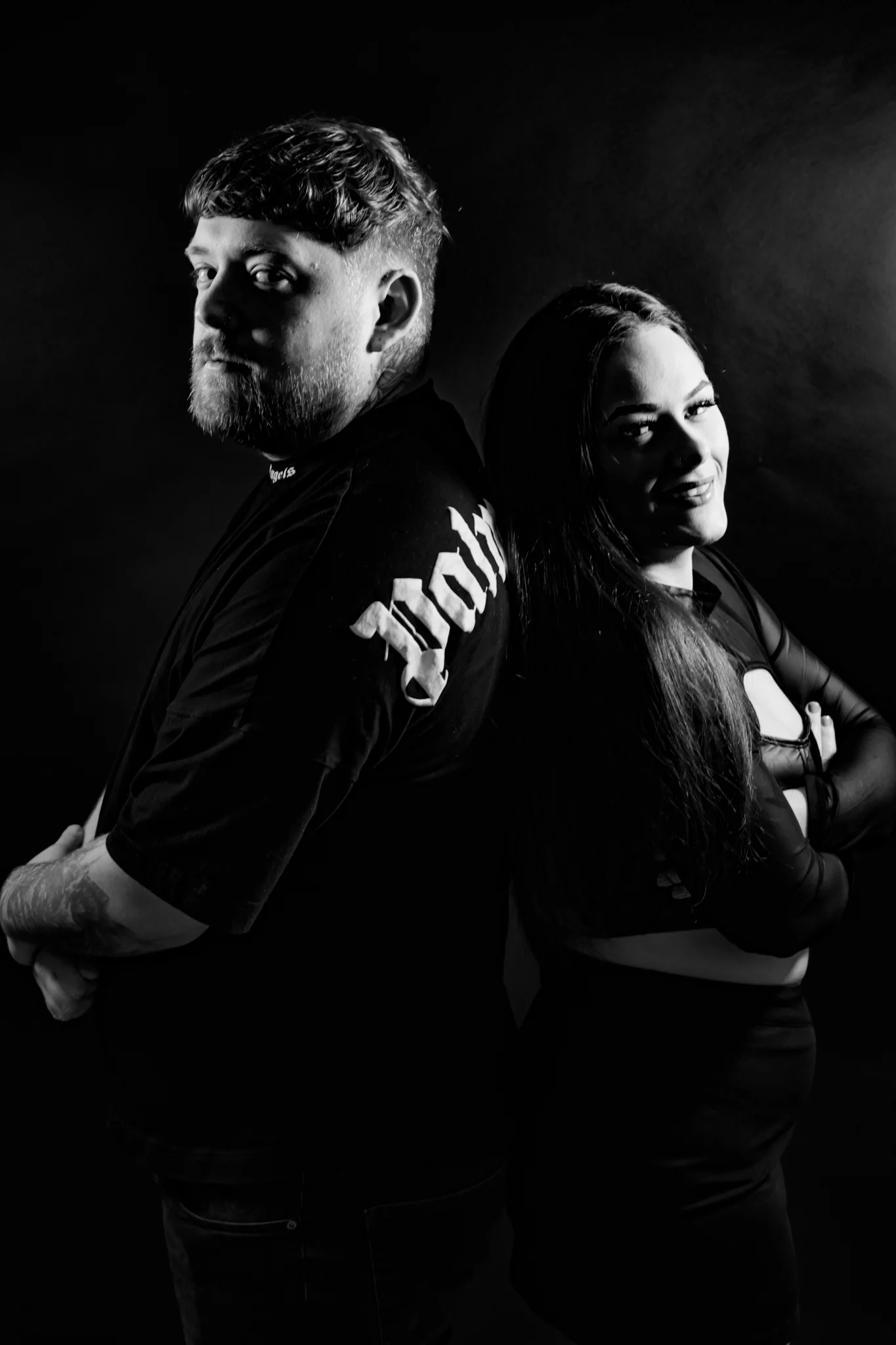 Jamie & Britney of Moodswing standing back to back in a black-and-white studio portrait