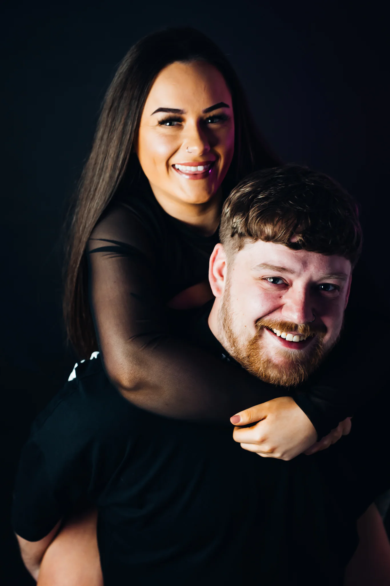 Britney smiling while leaning over Jamie's shoulders in a Moodswing studio portrait